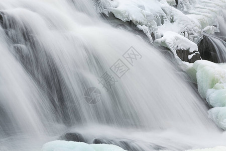 美国密歇根州上半岛邦德瀑布级联的冬季风景被冰雪笼罩图片