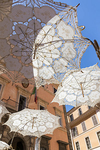 白色雨伞带蕾丝修饰装罗马的一条街背景图片