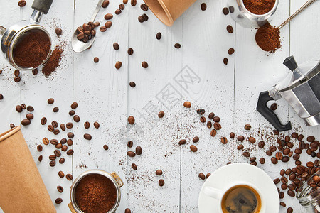 白色木制表面的脚过滤器勺子纸杯玻璃咖啡机和咖啡图片