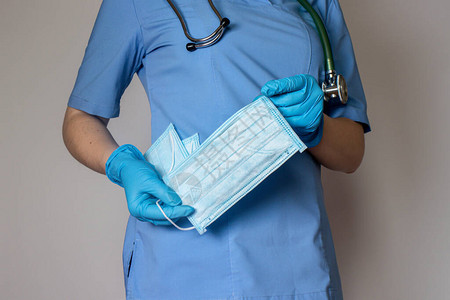 戴蓝色手套的医生拿着医用口罩图片