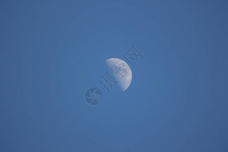 蓝色天空背景的日间月亮关闭背景图片