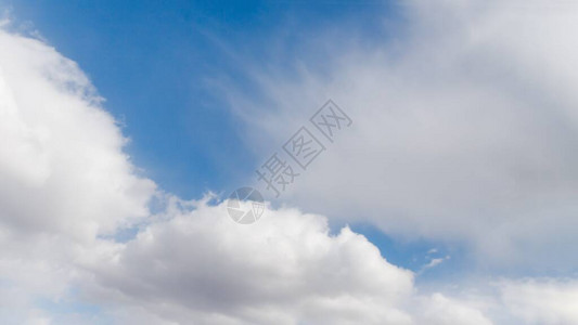 白毛和花状云彩在浅蓝天空中背景图片
