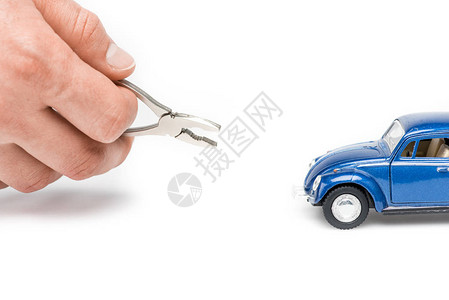 白色上持钳子和蓝色玩具车的男图片
