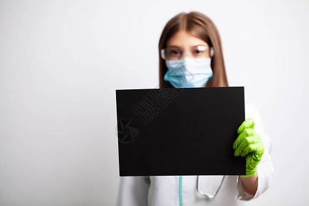 戴面罩的年轻女医生拿着一张空白纸图片