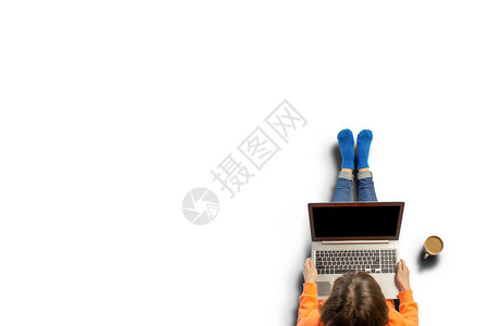 年轻女人跪着拿笔记本电脑站在咖啡边图片