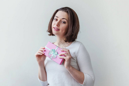 年轻积极的女人拿着粉红色的小礼盒图片