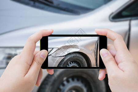 使用移动智能手机的妇女为事故保险而拍摄汽车撞的相片事故图片