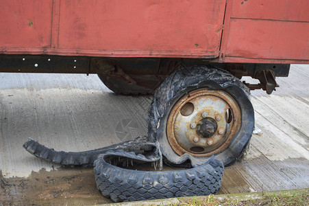 一个黑色的生锈橡胶大轮子破碎的破烂旧车满是轮胎图片