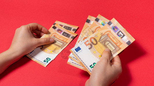 该男子在红色背景虑钞票50欧元的金额信用货图片