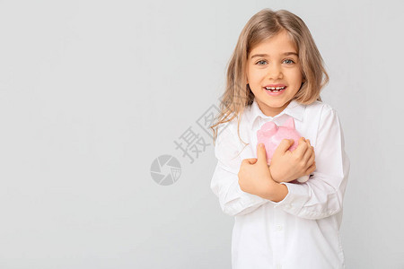 可爱的女孩与白色背景的存钱罐图片