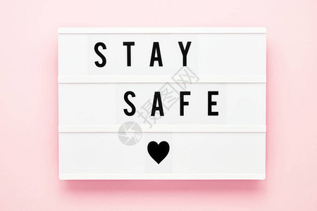保持安全写在粉红色背景的灯箱中医疗保健和医疗概念顶视图图片