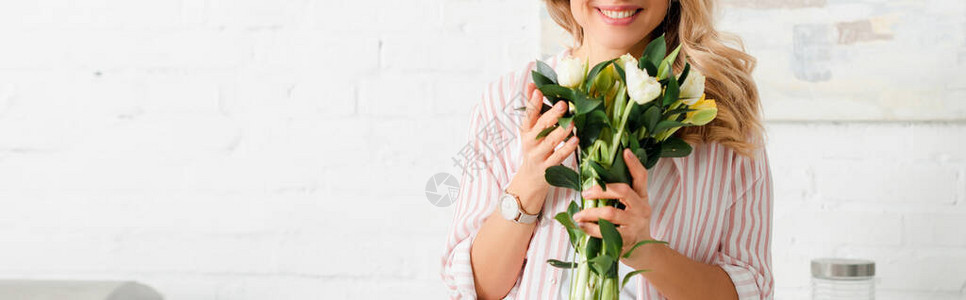 拿着郁金香花束的快乐女人的全景照片图片