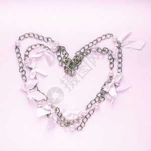 光粉色背景的连锁项链广场情人节爱情婚礼或浪漫概念图片