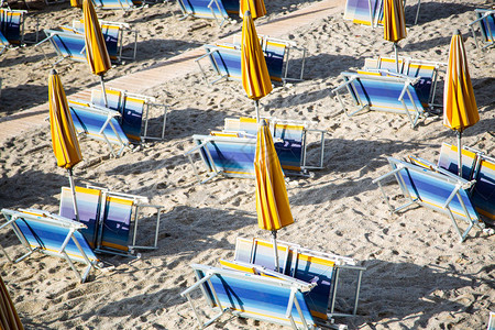 空荡的海滩有折叠的沙滩椅和遮阳伞图片