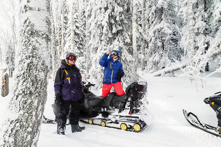 雪地上骑着运动车的运动员停下来享受冬图片