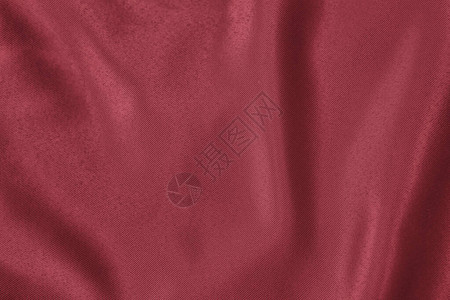 柔软的垂褶织物的深红色背景用于制作衣服和窗帘的漂亮缎面丝质布料优图片