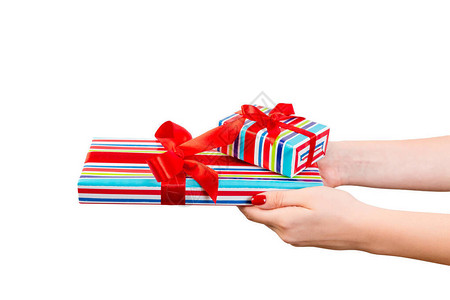 女人的手用红丝带用彩色纸给包装好的圣诞或其他节日手工礼物图片