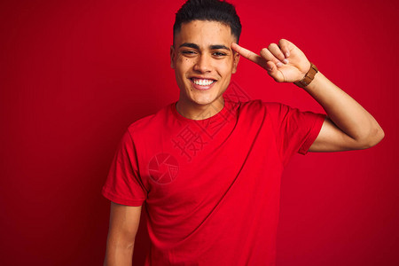 身穿T恤的巴西年轻男子站在孤立的红色背景上用一根手指微笑着指头图片