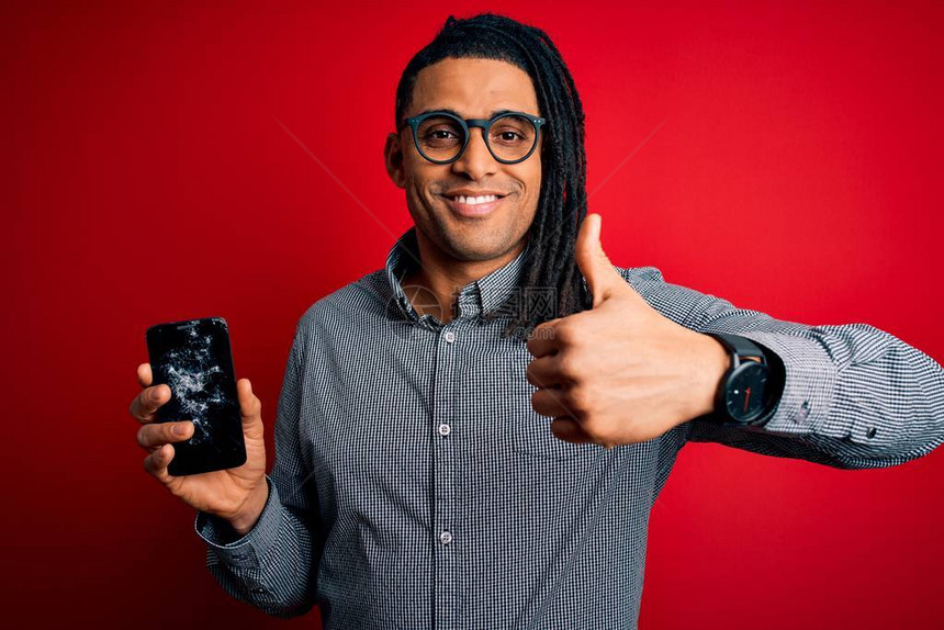 年轻的非洲裔美国黑人男子拿着破碎的智能手机图片