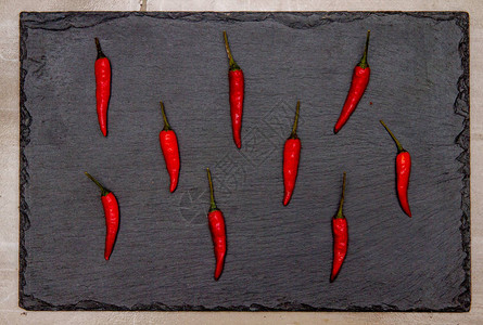 黑石板背景中的红辣椒图片