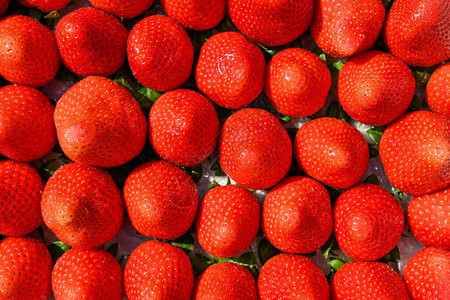 农贸市场上陈列的成熟红草莓背景图片