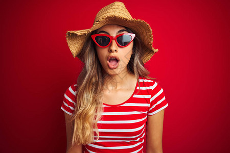年轻漂亮的女人戴着墨镜和夏天的帽子图片