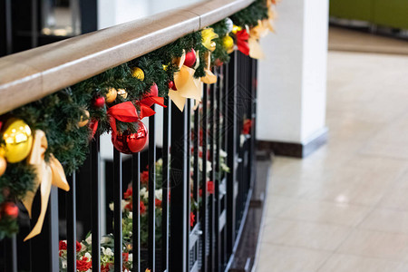室内栏杆上有丝带和球的圣诞装饰品图片