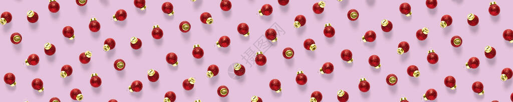 粉红色背景上的圣诞红色装饰品背景的圣诞饰品组成由红色饰品制图片