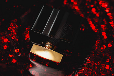 深红色背景中的黑色香水背景图片