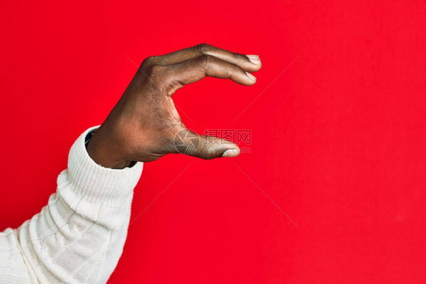 非洲裔美国黑人年轻人的手臂和手在红色孤立的背景下拾取和拿走看不见的东西图片