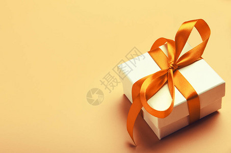 黄色背景上有橙色亮丝带的白色礼品盒圣诞节生日的精美礼图片