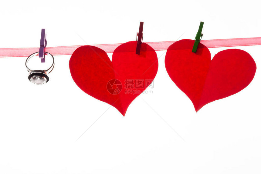 红纸心在白色背景的衣物上情人节和婚姻求婚的概念中写图片