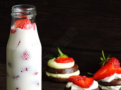 巧克力饼干加奶油酪和草莓草莓牛奶饮料装在瓶子里最佳景色薄背景图片