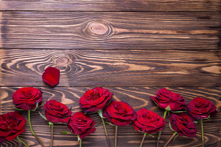 从带纹理的木制背景上的红色新鲜玫瑰花边框花卉静物文本的地方背景图片