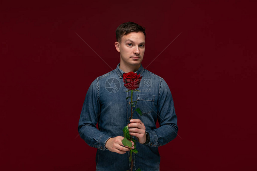 年轻漂亮男人拿着一朵红玫瑰献给他的爱人在圣情人节向女友们做礼物