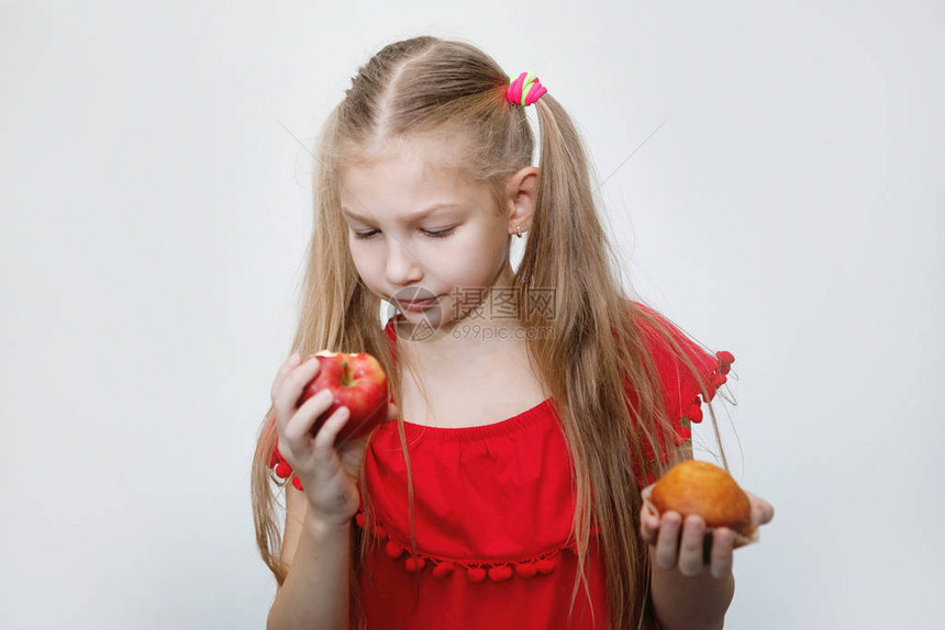 扎着马尾辫的金发少女吃着一个红苹果图片
