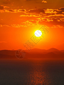 太阳光照耀在山顶的环影和海面上日光束涂色以橙色为地平线背景壁背景图片