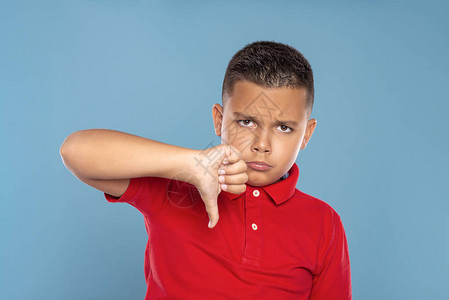 一个男孩的肖像拿着他的食指向下展示一个手势显示每件事都不好图片