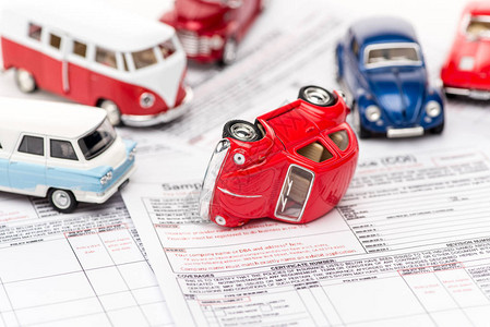 在保险单据上选择多彩玩具汽车背景图片