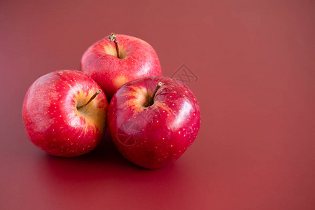 在红桃背景上有三个红苹果盛会图片