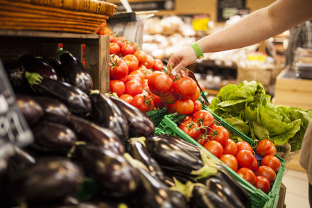 女人在超市蔬菜柜台摘西红柿的手图片