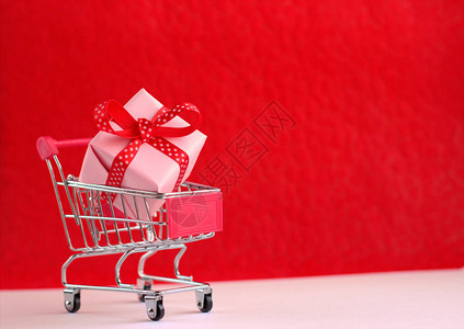 红色背景的红购物车和礼品盒图片