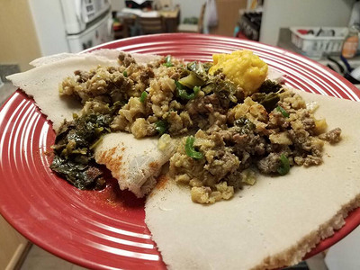 埃塞俄比亚菜食辣牛肉和肠蔬菜以及厨房红盘上面图片
