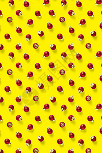 黄色背景上的圣诞红色装饰品背景的圣诞饰品组成由红色饰品制图片