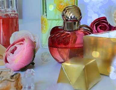 香水瓶红玻璃白金底的鲜花背景图片