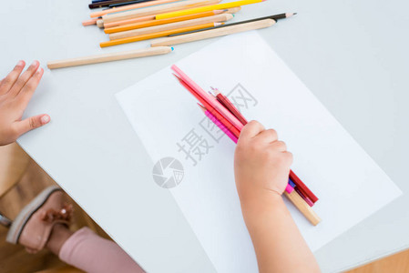 儿童在纸边拿着彩色铅背景图片