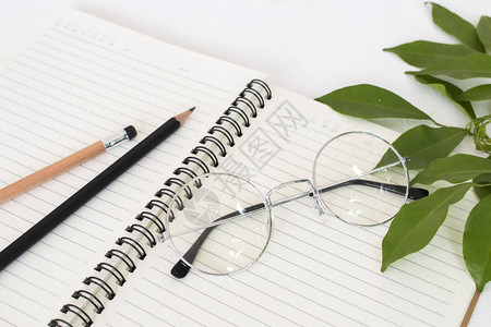 笔记本用铅笔写备忘录的笔记本在背景白图片