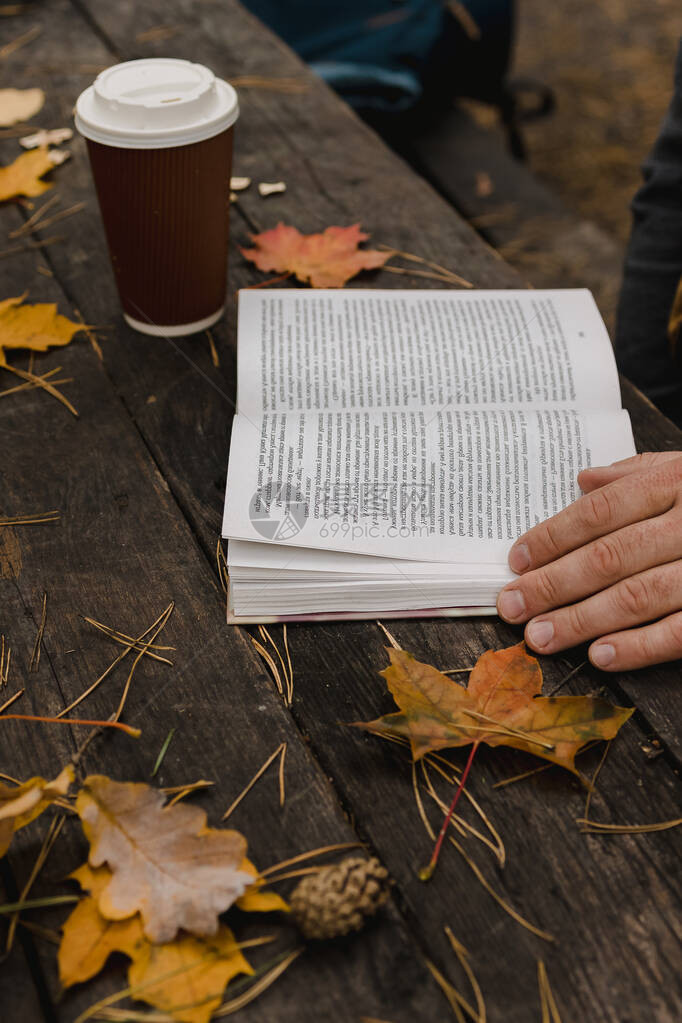男在秋天公园看一本书图片