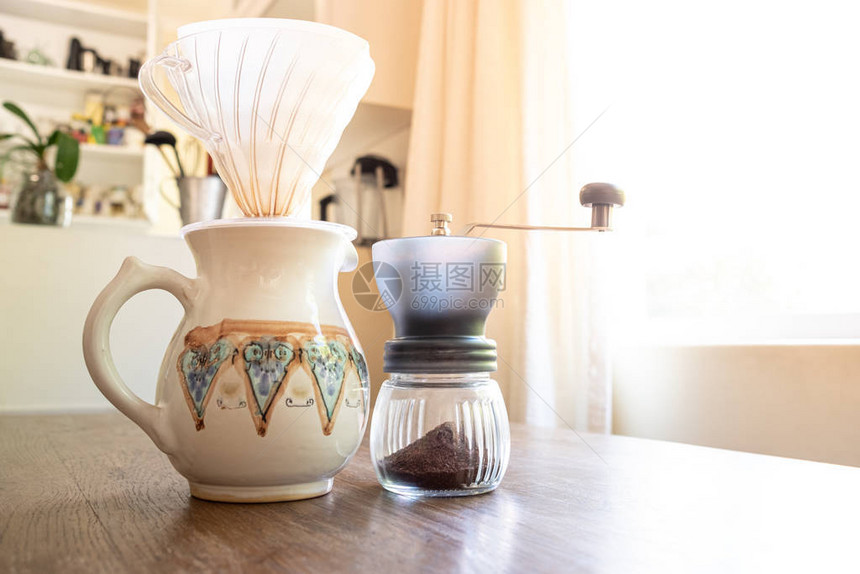 把家里准备好的咖啡倒在一个带白色杯子的老式壶上图片