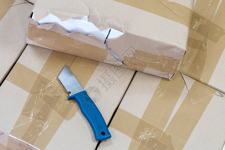 带包裹的封闭盒子和用于打开盒子的刀打印包图片